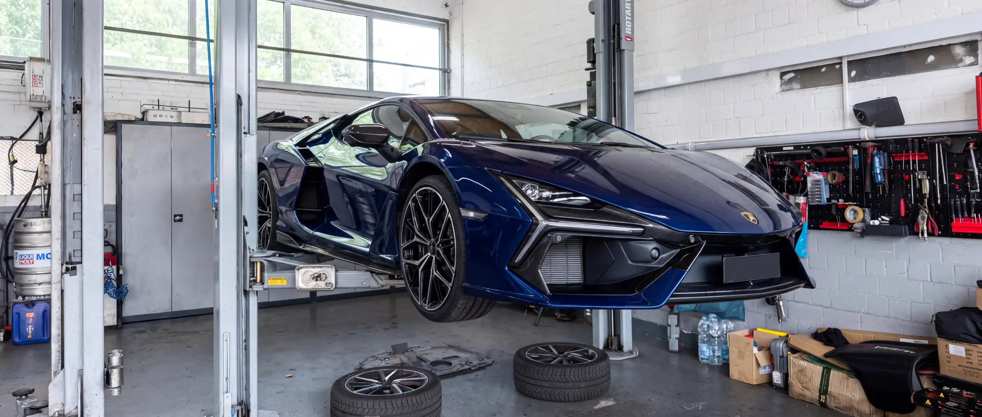 Blauer Sportwagen auf der Hebebühne in der Werkstatt bei der Fahrzeugfehlerdiagnose